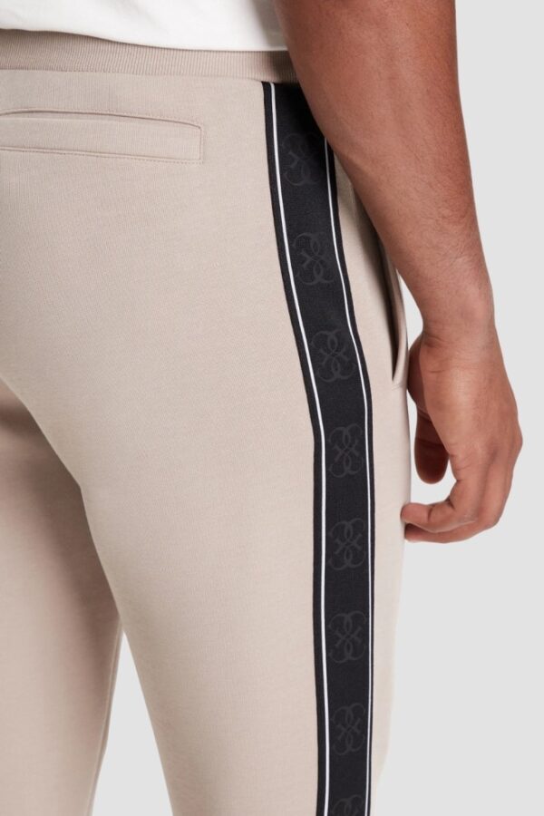GUESS Beżowe spodnie męskie z lampasami Mickey