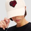 49be9a3e57d1391ac2ae7bc50192c324e9f8abaa KARL LAGERFELD Beżowa damska czapka z daszkiem z serce