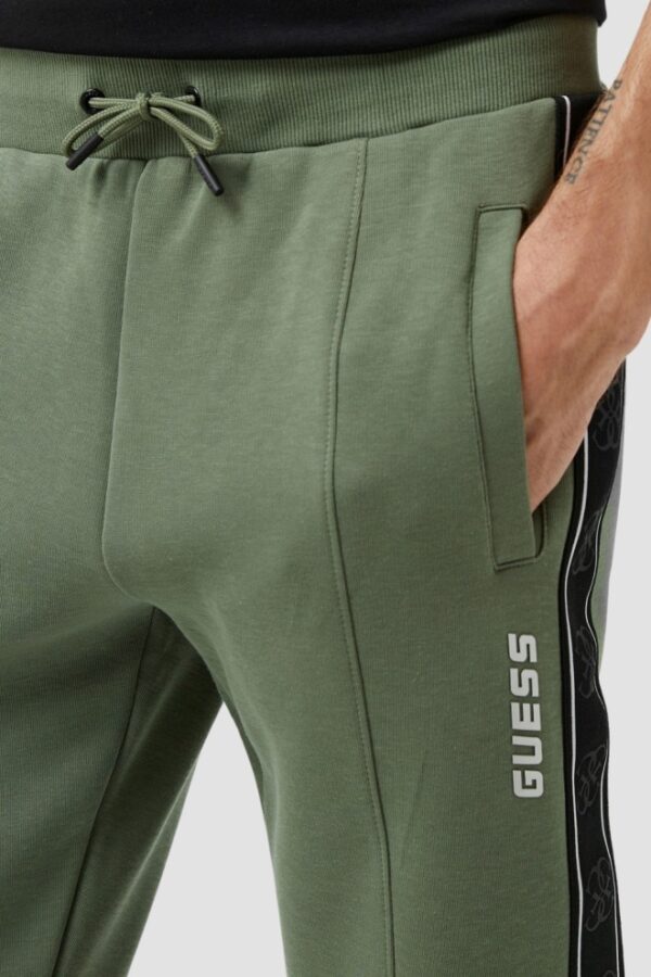 GUESS Zielone męskie spodnie dresowe z lampasami Mickey